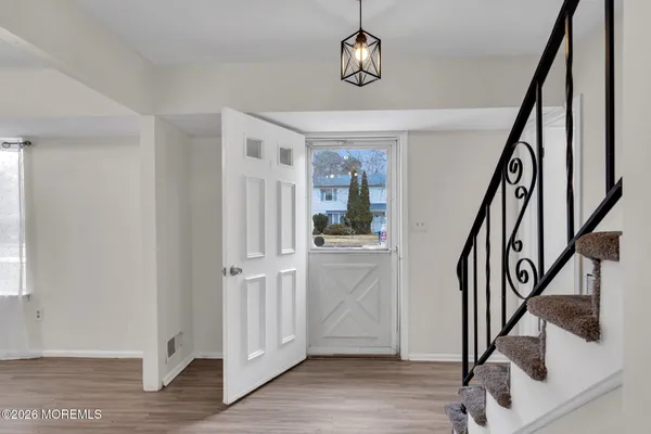 a view of a hallway with wooden floor and staircase