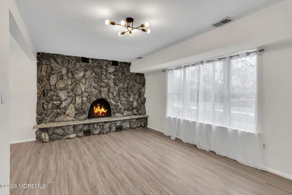 a view of an empty room with a fireplace and a window