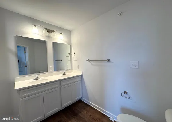 a bathroom with a double vanity sink toilet and mirror