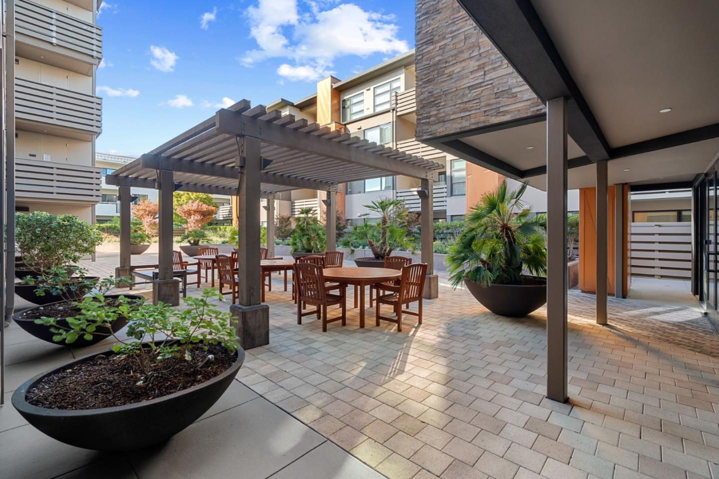 1838 Ogden Drive, Unit 413 Burlingame, CA 94010 - Photo 21 of 23 a view of a patio with table and chairs potted plants