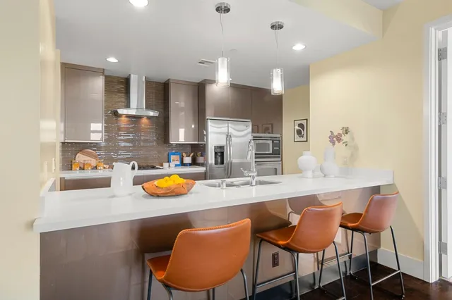 a kitchen with stainless steel appliances kitchen island granite countertop a table and chairs