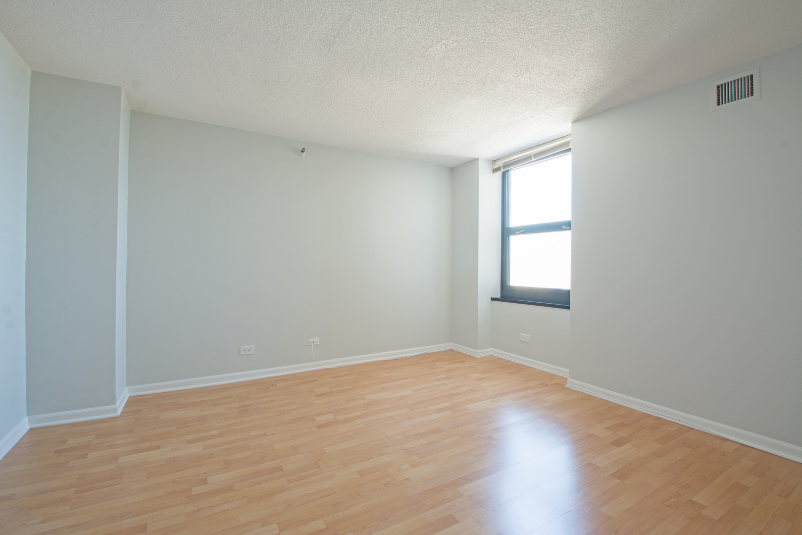 3660 North Lake Shore Drive, Unit 3910 Chicago, IL 60613 - Photo 15 of 25 a view of an empty room with wooden floor and a window