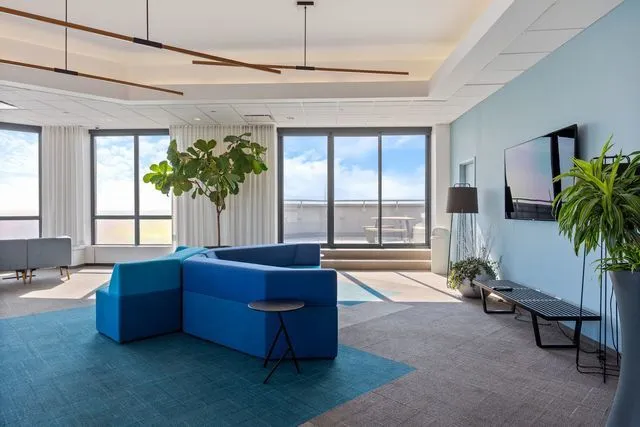 a living room with stainless steel appliances kitchen island granite countertop lots of white furniture and a view of living room