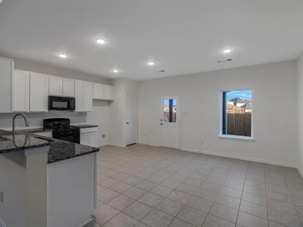 a kitchen with granite countertop white cabinets and stainless steel appliances