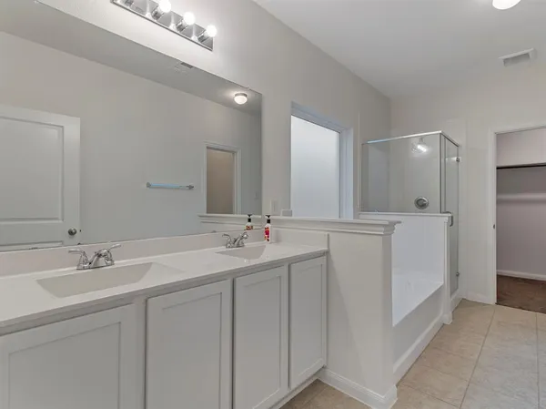 a bathroom with a double vanity sink mirror and cabinets