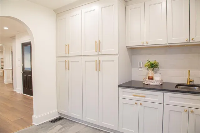 a kitchen with white cabinets and window