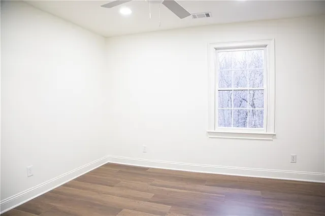 a bathroom with a granite countertop sink a toilet and a mirror