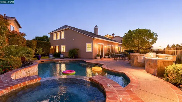 a view of a house with swimming pool and sitting area