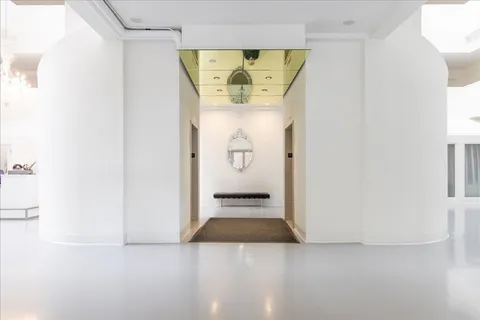 a front view of a house with a yard and fountain in middle