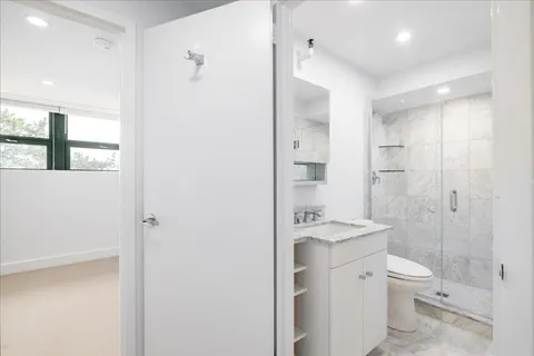 a bathroom with a granite countertop sink toilet a shower and a mirror