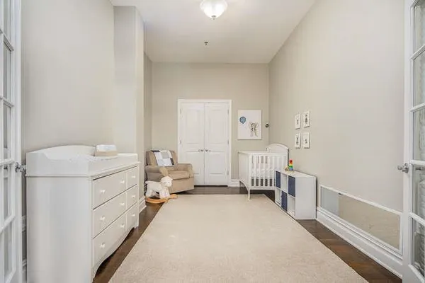 a room with a baby crib dresser and a window