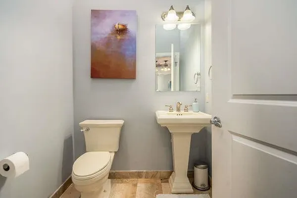 a bathroom with a toilet sink and mirror