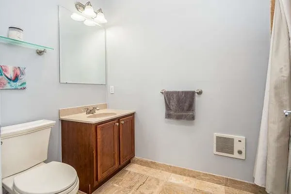 a bathroom with a toilet a sink and mirror