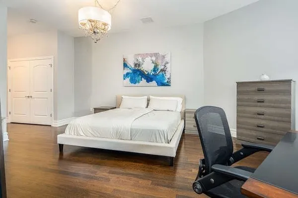 a bedroom with a bed and a chandelier