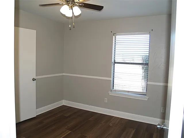 a view of a small space with wooden floor and a window