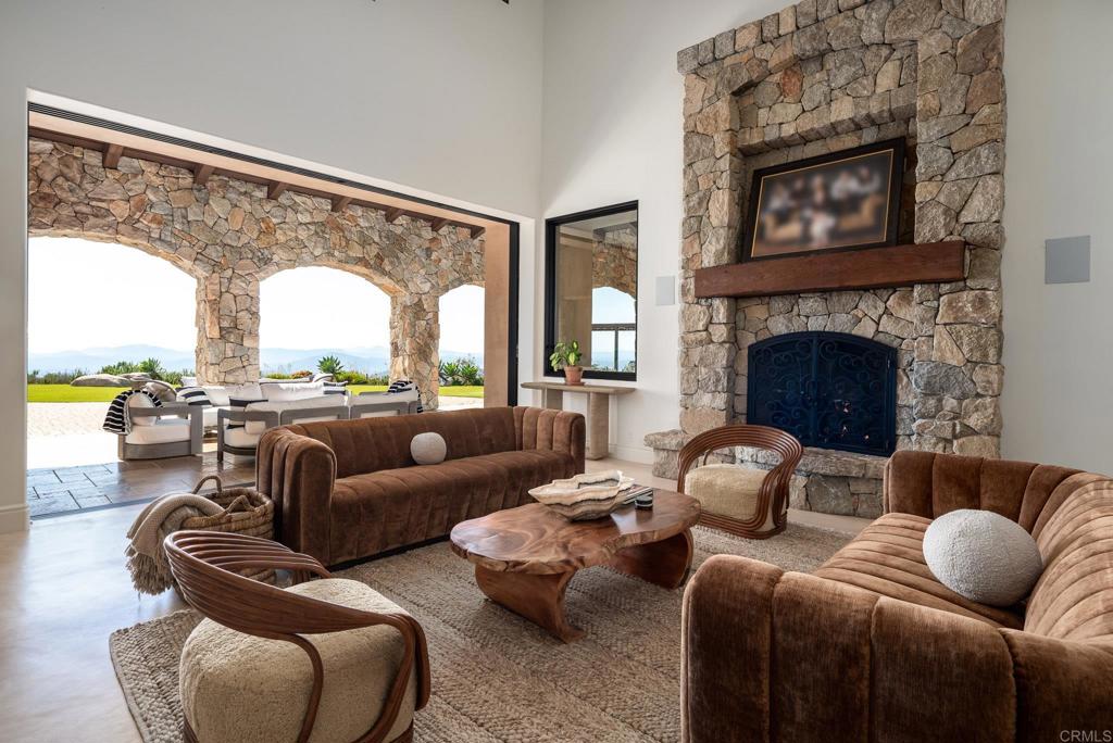 18000 Sunset Point Road Poway, CA 92064 - Photo 9 of 36 a living room with furniture a fireplace and floor to ceiling windows