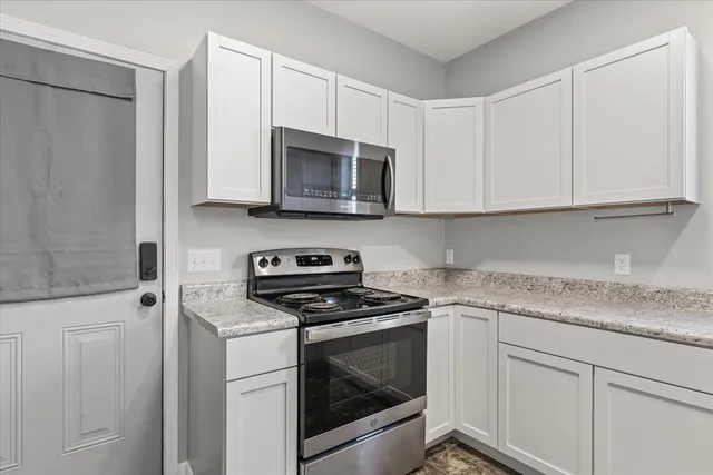 a kitchen with white cabinets and white appliances