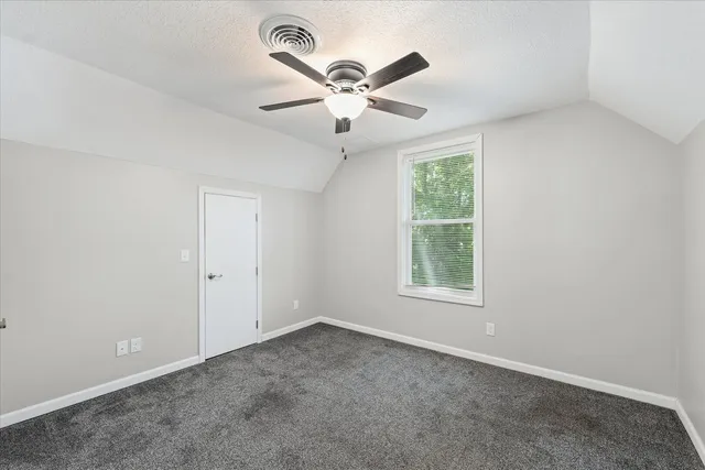 an empty room with window and a ceiling fan