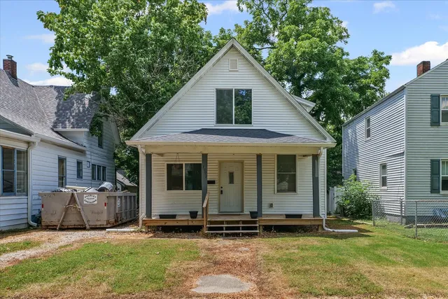a view of a house with a yard and sitting area