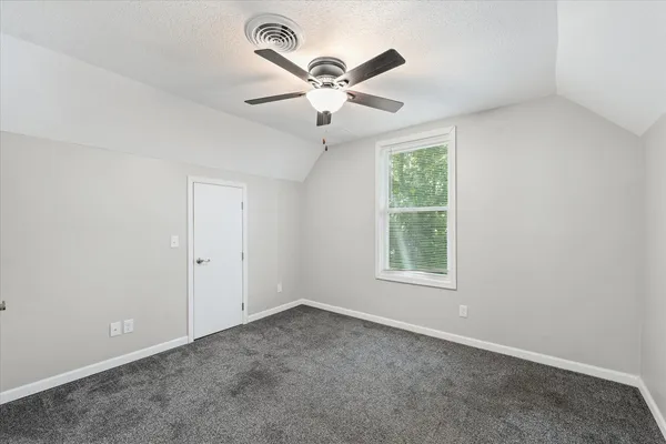 an empty room with window and a ceiling fan