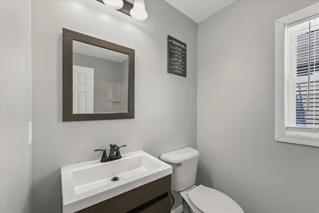 a bathroom with a toilet sink and mirror