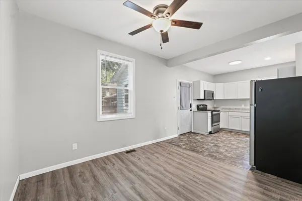 a view of kitchen with stainless steel appliances granite countertop a refrigerator and a stove top oven