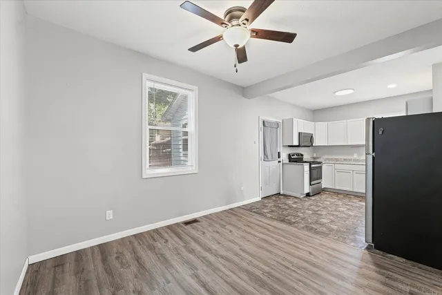 a view of kitchen with stainless steel appliances granite countertop a refrigerator and a stove top oven