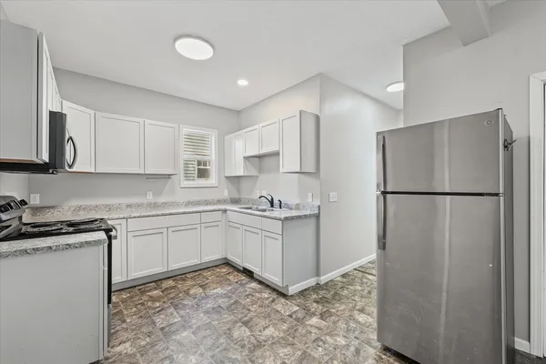 a kitchen with a refrigerator sink and cabinets