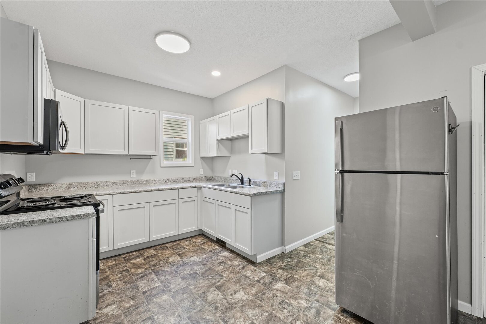 1391 West Decatur Street Decatur, IL 62522 - Photo 9 of 28 a kitchen with a refrigerator sink and cabinets