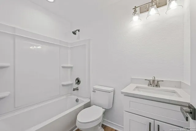 a bathroom with a bathtub shower sink vanity and toilet