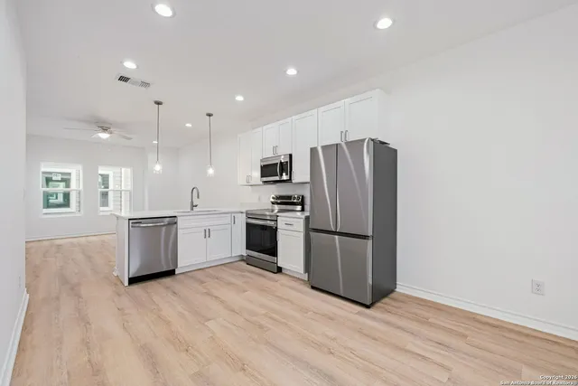 a kitchen with a refrigerator and a stove top oven