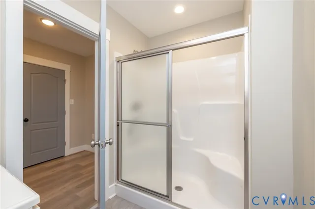 a bathroom with a glass shower door and a bathtub