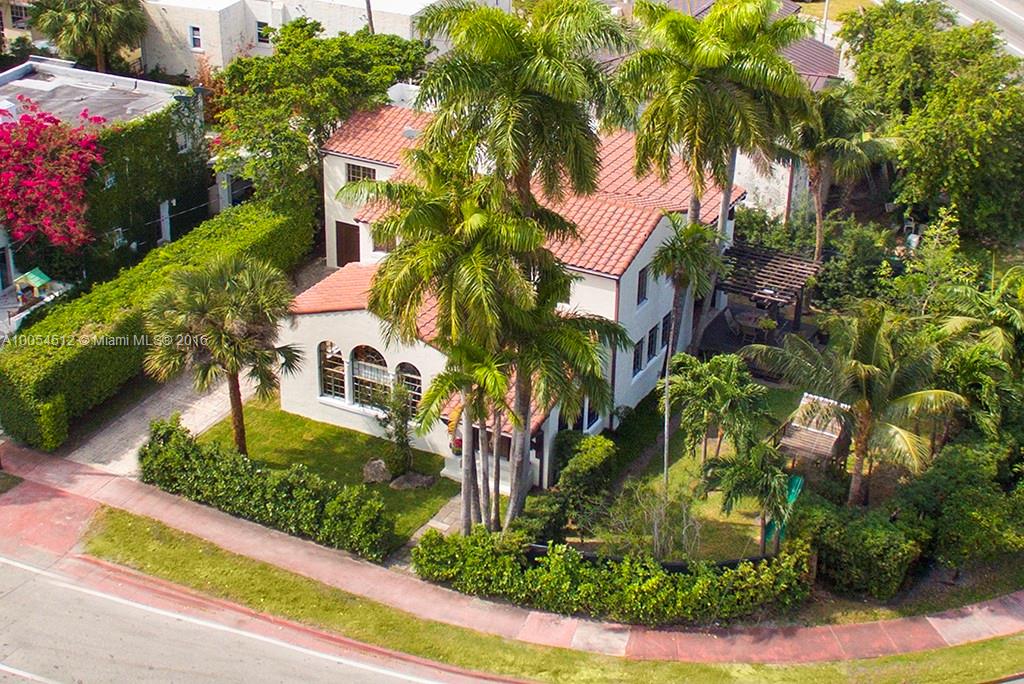a front view of multi story residential apartment building with yard and sign board