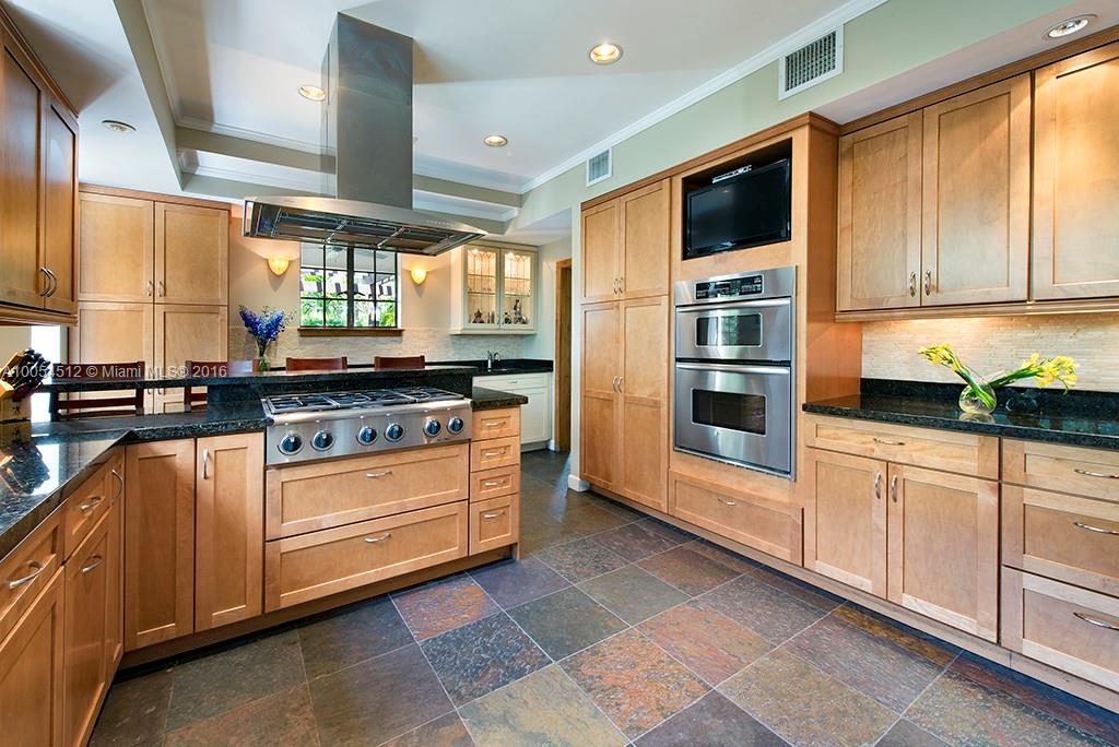 4236 Alton Road Miami Beach, FL 33140 - Photo 6 of 24 a kitchen with stainless steel appliances granite countertop a stove and a microwave