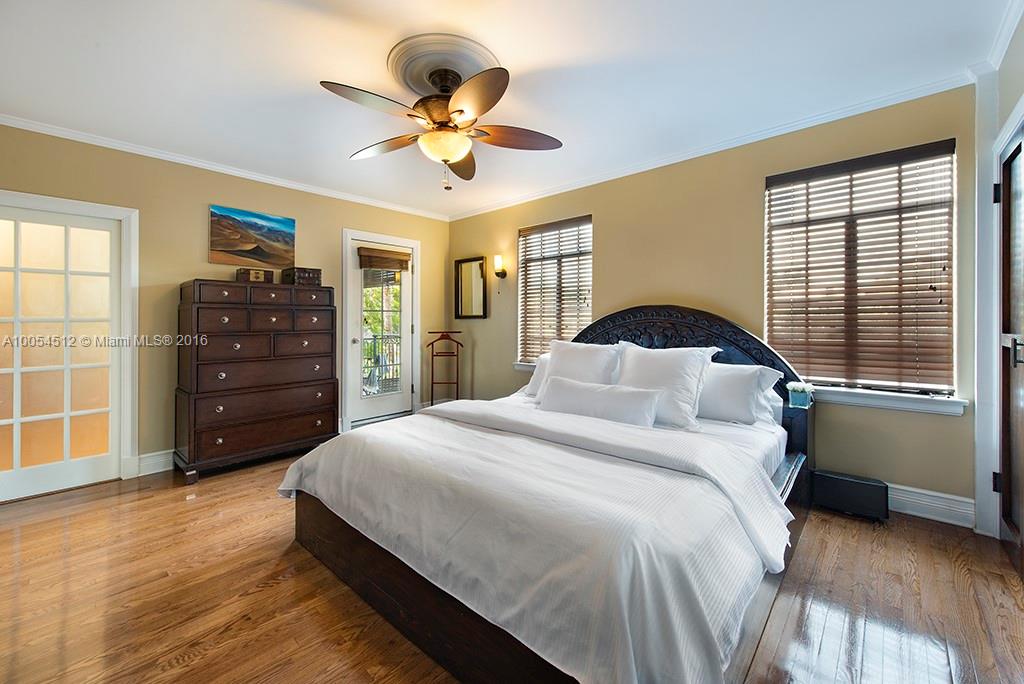 4236 Alton Road Miami Beach, FL 33140 - Photo 8 of 24 a bedroom with a bed and a chandelier