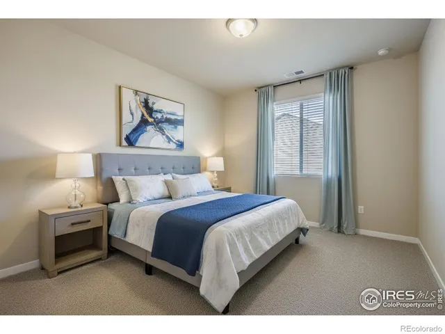 a bedroom with a bed and a painting on the wall