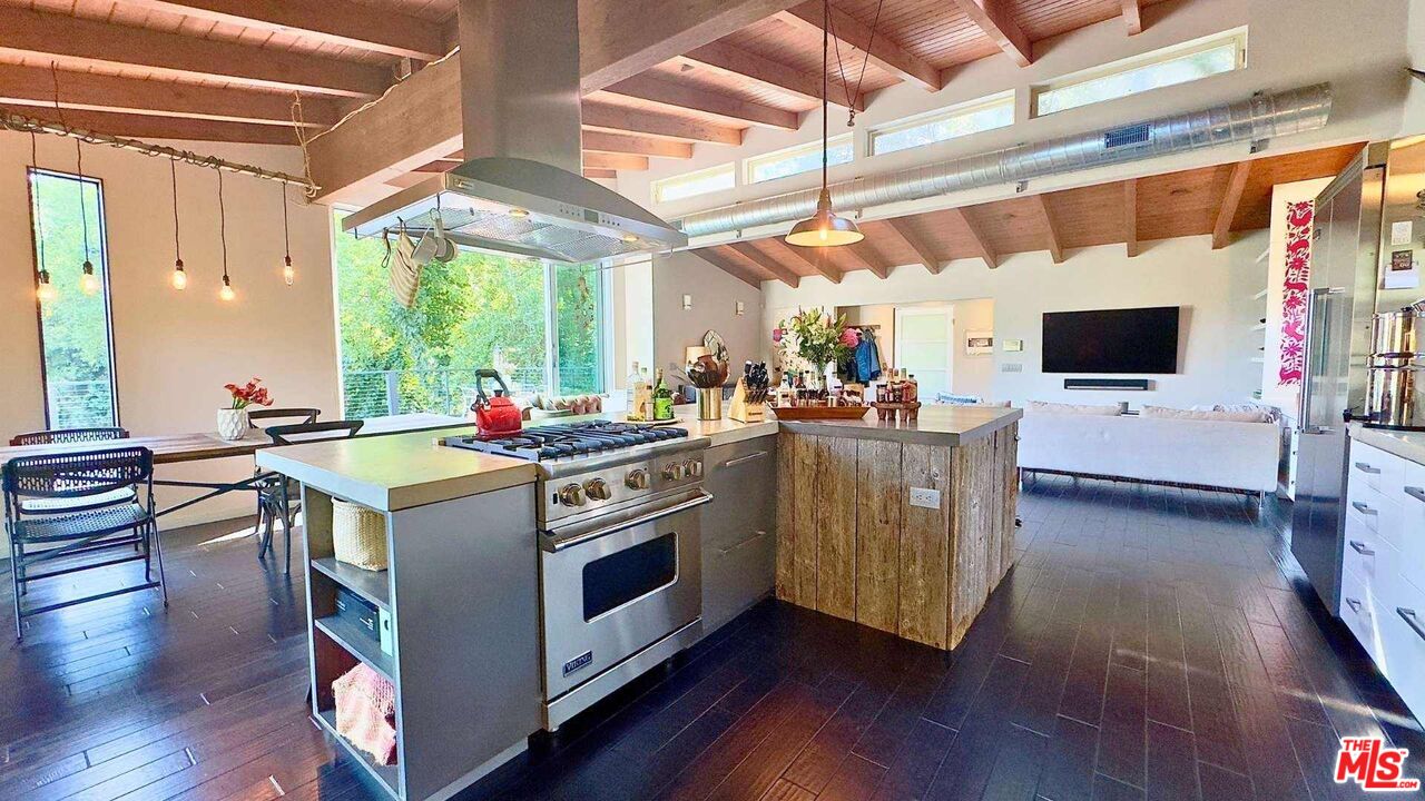 19562 Cave Way Topanga, CA 90290 - Photo 8 of 29 a kitchen with stainless steel appliances kitchen island granite countertop a stove and a view of living room