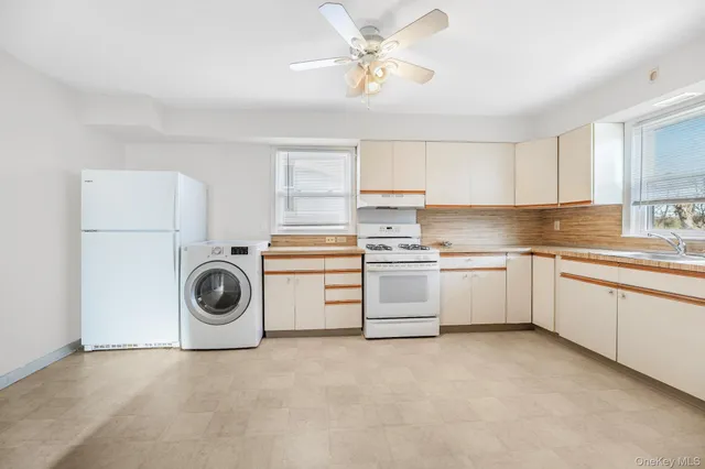 a kitchen with cabinets a sink and white appliances