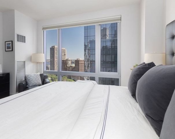 a bedroom with a large bed and a large window