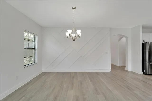 an empty room with windows and ceiling fan