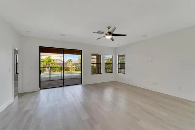 an empty room with windows and fan