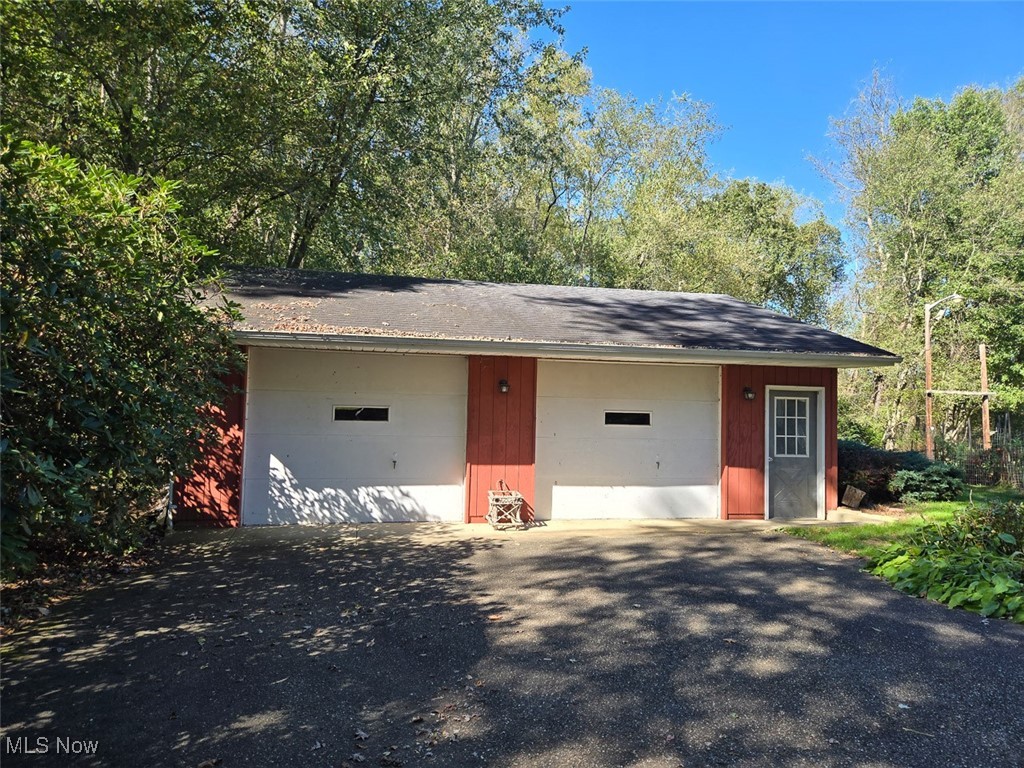 715 Minerva Road Magnolia, OH 44643 - Photo 7 of 26 View of a garage, with a shingled roof