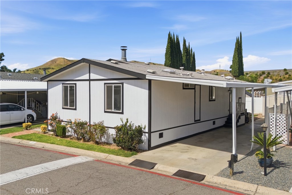 4901 Green River Road, Unit 153 Corona, CA 92878 - Photo 1 of 55 a front view of a house with garden
