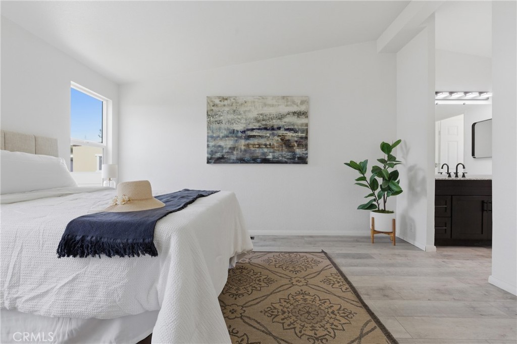 4901 Green River Road, Unit 153 Corona, CA 92878 - Photo 18 of 55 a bedroom with a large bed and a potted plant