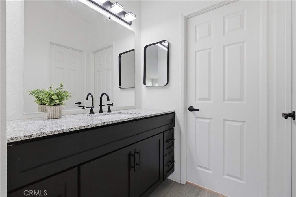 4901 Green River Road, Unit 153 Corona, CA 92878 - Photo 19 of 55 a bathroom with a granite countertop sink a mirror and vanity
