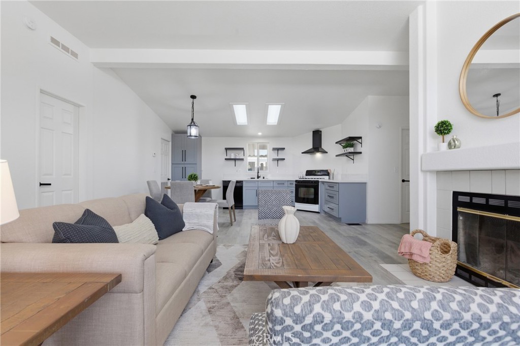 4901 Green River Road, Unit 153 Corona, CA 92878 - Photo 6 of 55 a living room with furniture a fireplace and a table