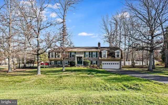 a view of a house with a big yard and large trees