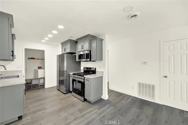 a kitchen with stainless steel appliances a stove top oven a sink and a refrigerator