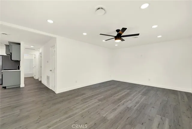 a view of a room with wooden floor and a ceiling fan