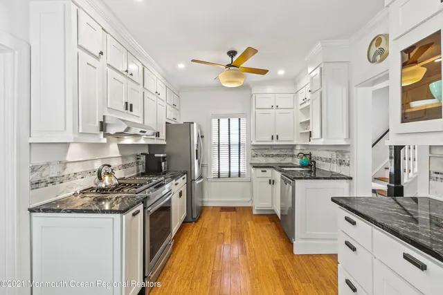 a kitchen with stainless steel appliances granite countertop a lot of cabinets a stove and a sink